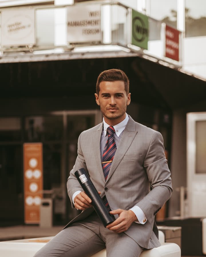 Andreas Schmid, grey suit and striped tie in the city