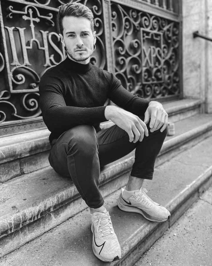 Andreas Schmid, black and white photo seated on stone steps