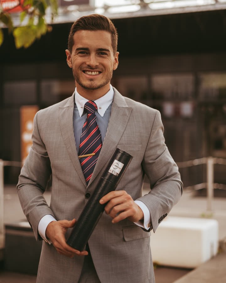 Andreas Schmid, smiling in a grey suit and striped tie